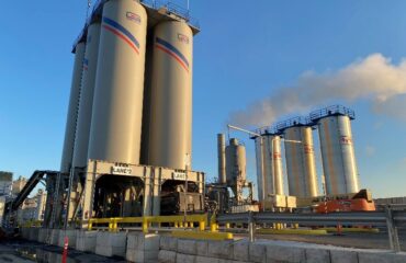 City Asphalt drum plant silos and production equipment under a blue sky in Staten Island.