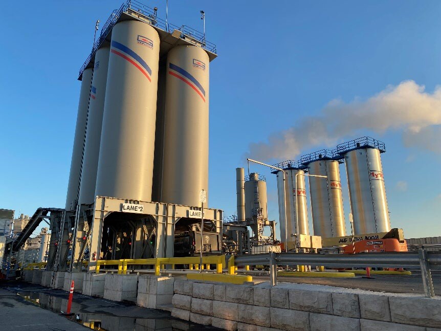 City Asphalt, Staten Island: SIP-1111™ in a 45% RAP Field Study City Asphalt drum plant silos and production equipment under a blue sky in Staten Island.