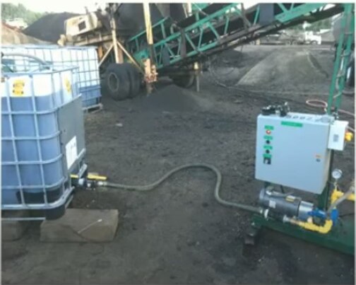 Emily, Minnesota: SIP-1111™ in the TH 6 Recycling-Agent Study Rejuvenator tote connected by hose to a metering skid beside asphalt plant equipment in Emily, Minnesota.