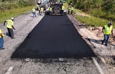 Paving crew placing the dark 50 percent RAP surface layer on NCAT Test Track Section S1.