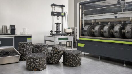 What the AASHTO PEAS Evaluation Shows for SIP-1111™ Asphalt specimens and laboratory testing equipment arranged around a roadway-materials workbench.