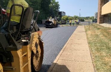 A roller and paving crew work beside the Indiana Soybean Alliance headquarters.