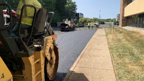 A roller and paving crew work beside the Indiana Soybean Alliance headquarters.